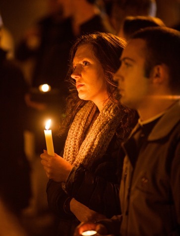 A young woman holds a candle in St. Peter's Square as the period of the Sede Vacante begins Feb. 28.  Pilot photo/Gregory L.  Tracy